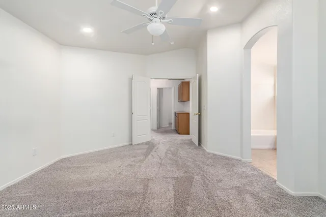 an empty room with closet and a chandelier fan