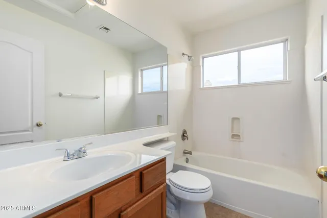 an empty room with a windows and ceiling fan