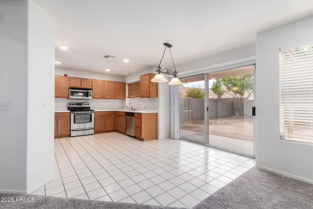 a open kitchen with stainless steel appliances granite countertop a refrigerator and a sink