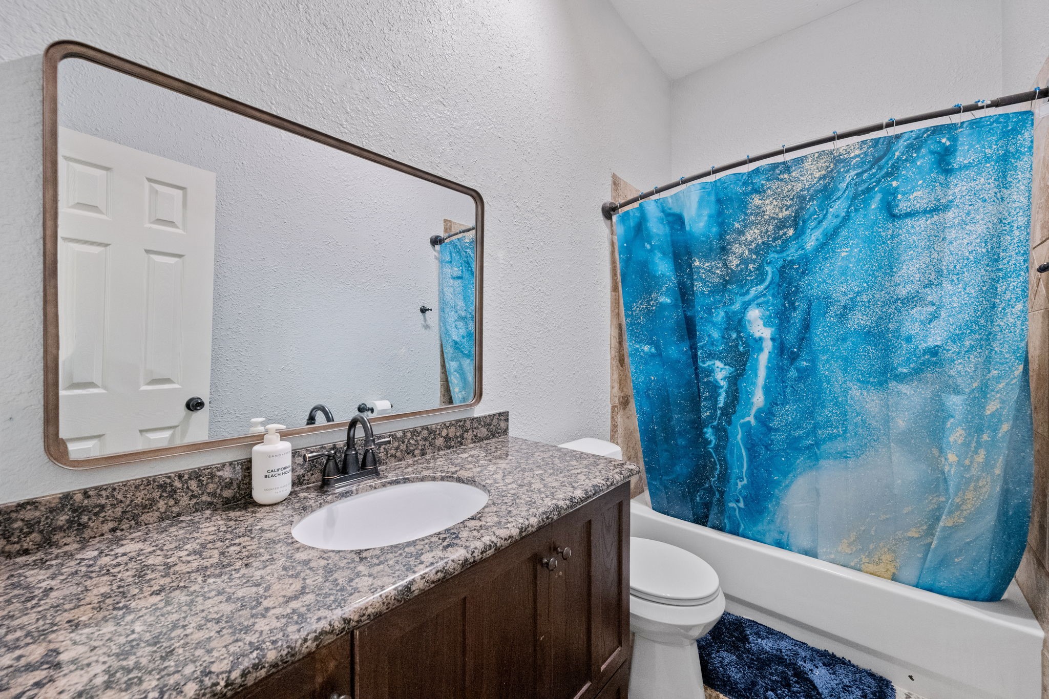 5809 Cajun Way Baytown, TX 77523 - Photo 21 of 29 a bathroom with a granite countertop sink a toilet a mirror and shower curtain
