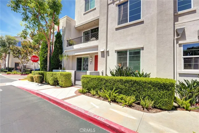 a view of a building with a yard and potted plants
