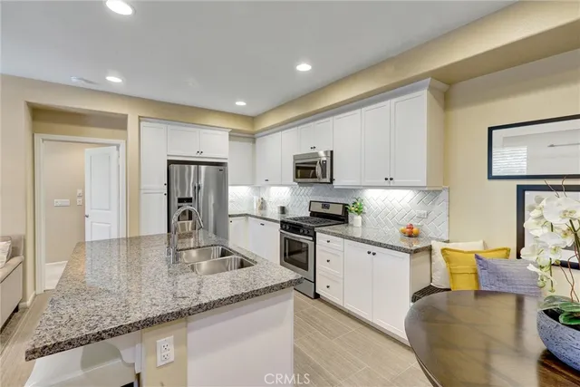 a kitchen with granite countertop stainless steel appliances a stove a refrigerator a sink a counter space and cabinets