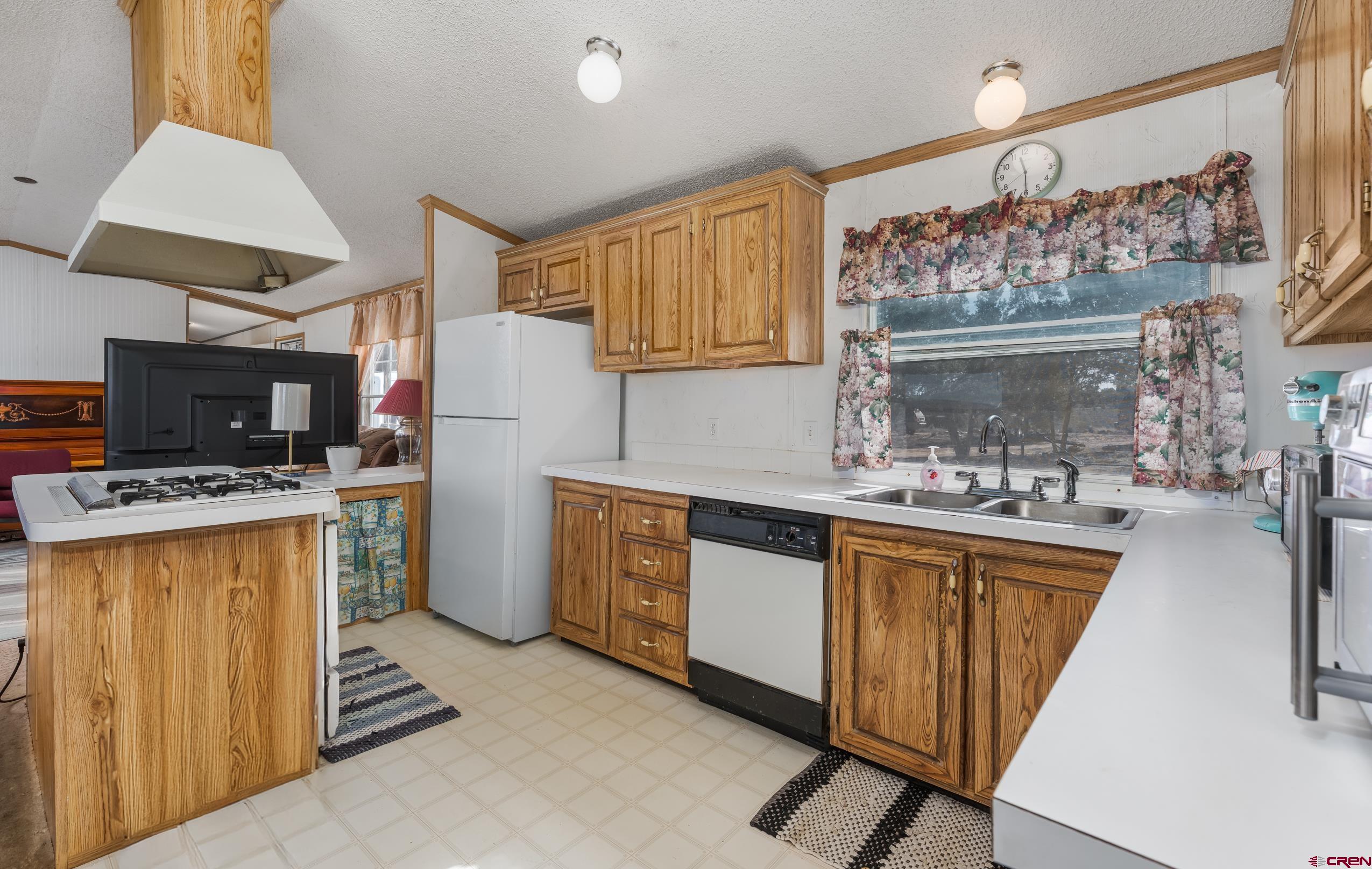 1837 Anna Road Ignacio, CO 81137 - Photo 17 of 32 a kitchen with a stove a sink and a refrigerator