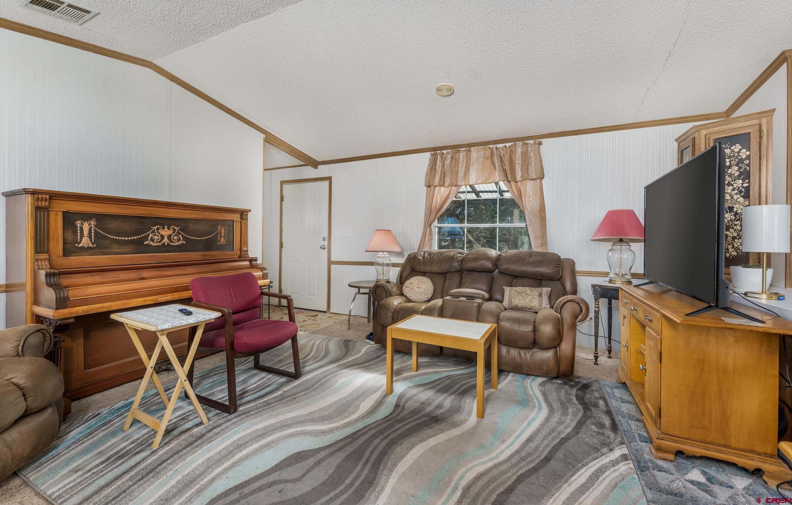 1837 Anna Road Ignacio, CO 81137 - Photo 24 of 32 a living room with furniture a flat screen tv and a window