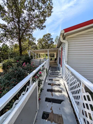 a balcony with wooden floor and trees in the back