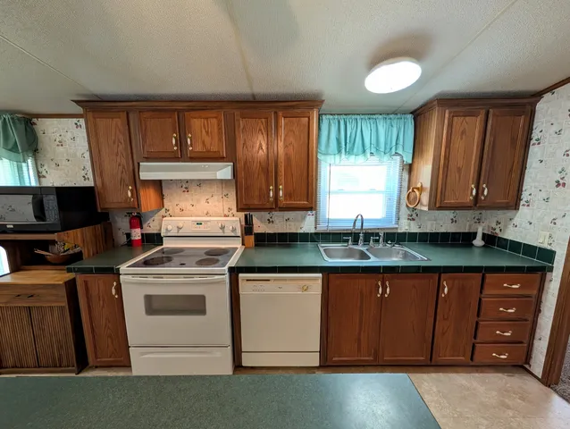 a kitchen with granite countertop wooden cabinets a sink and a stove