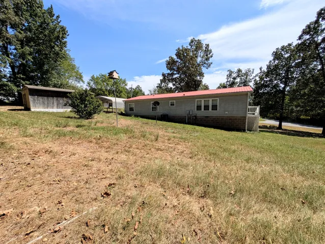 a view of a field with some trees in front of it