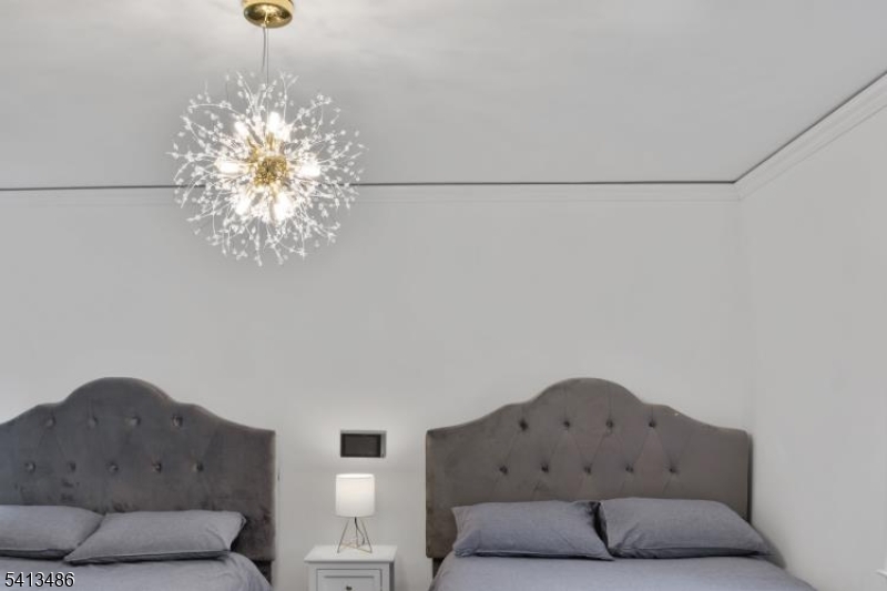 224 Swarthmore Road Linden, NJ 07036 - Photo 22 of 33 a spacious bedroom with a bed and a chandelier