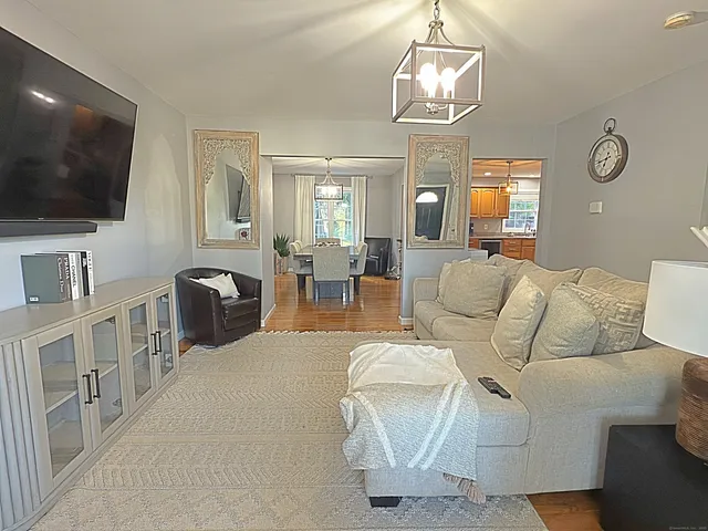 a living room with furniture a flat screen tv and kitchen view