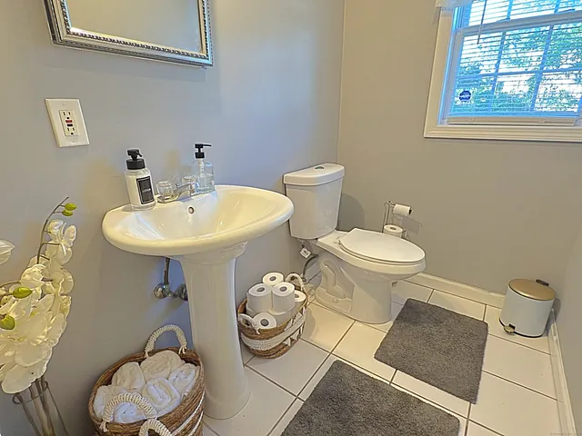 a bathroom with a sink toilet and a mirror