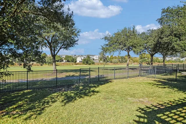 a view of a yard with wooden fence