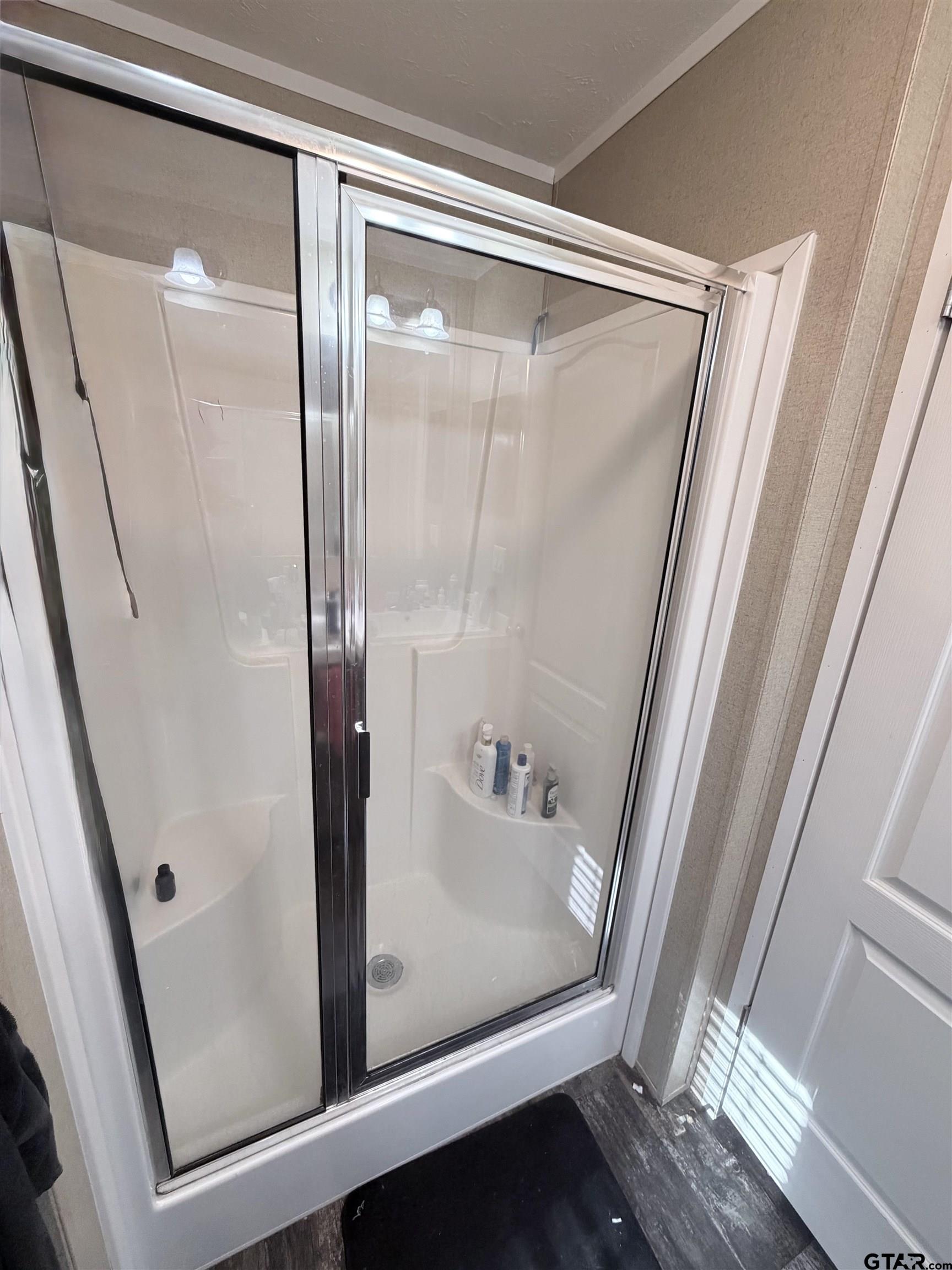 11300 Highway 271, Unit 52 Tyler, TX 75708 - Photo 12 of 16 a bathroom with a glass shower door and a sink