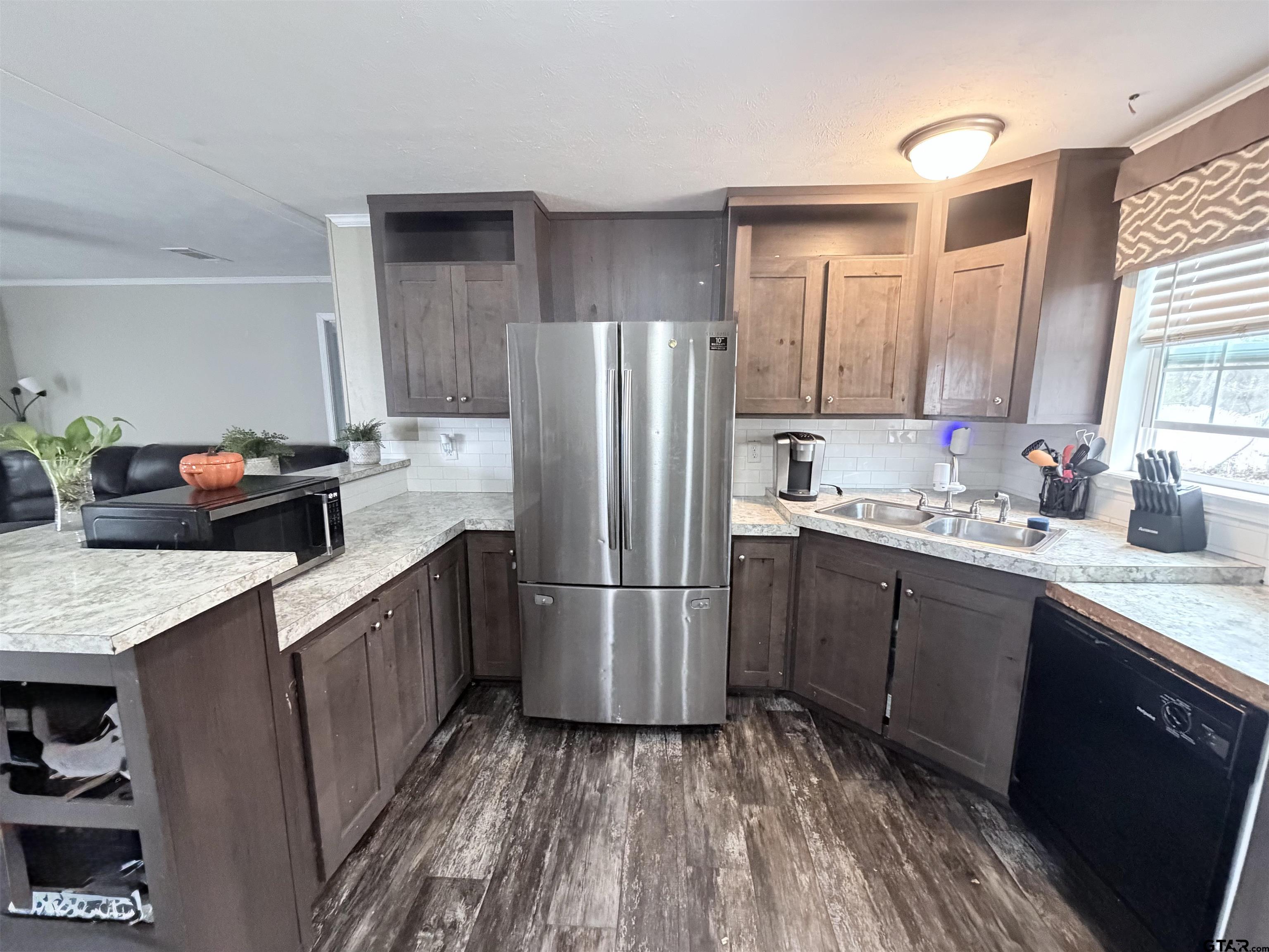 11300 Highway 271, Unit 52 Tyler, TX 75708 - Photo 3 of 16 a kitchen with a sink refrigerator and cabinets
