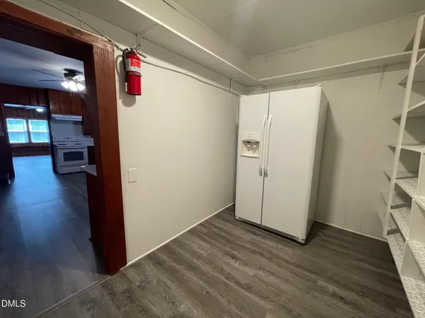 a view of a hallway with wooden floor and closet