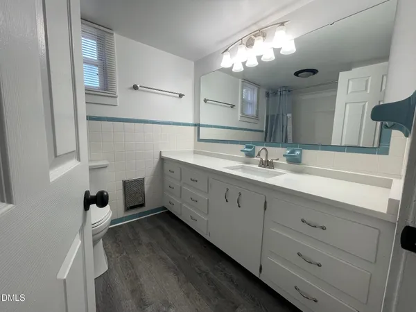 a spacious bathroom with a double vanity sink a mirror and shower
