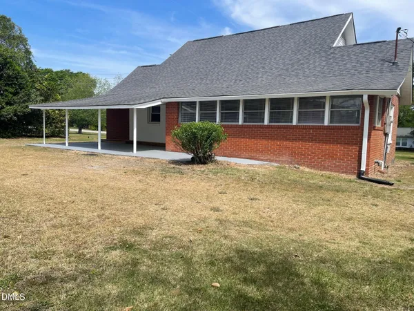 a view of house with backyard and porch