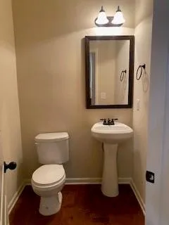 a bathroom with a toilet sink and mirror