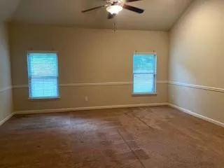 an empty room with windows and cabinet