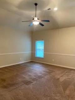 a view of an empty room with a chandelier fan