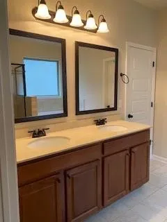 a bathroom with a double vanity sink and a mirror