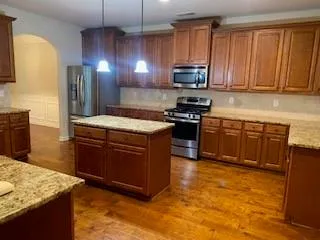 a kitchen with stainless steel appliances granite countertop a stove a sink dishwasher and a refrigerator