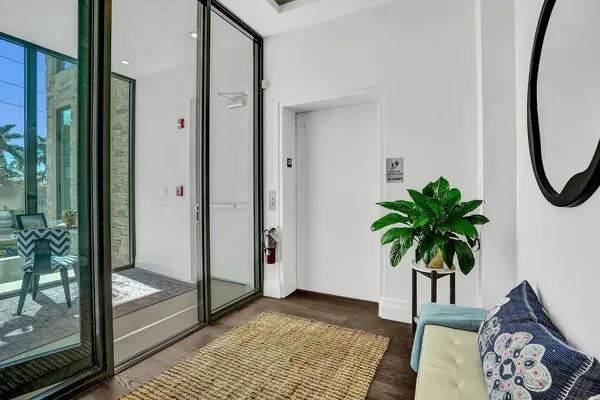 a view of a hallway with paintings on the floor and a potted plant