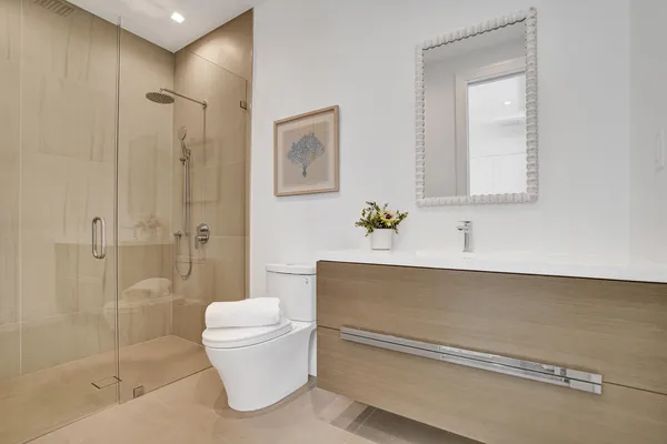 a bathroom with a sink a toilet and shower