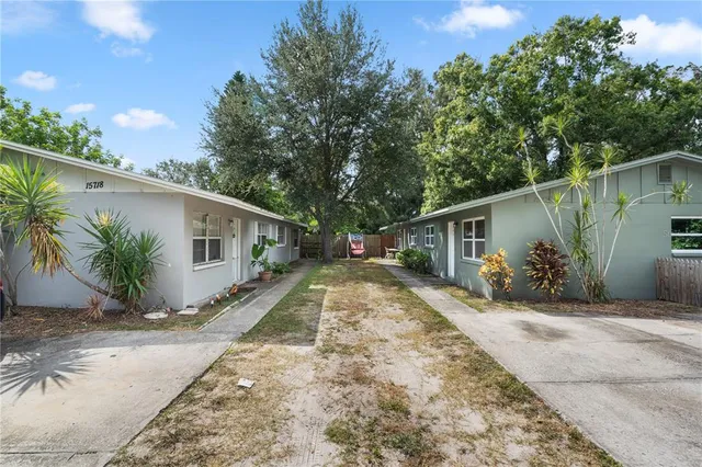 a front view of a house with a yard and potted plants