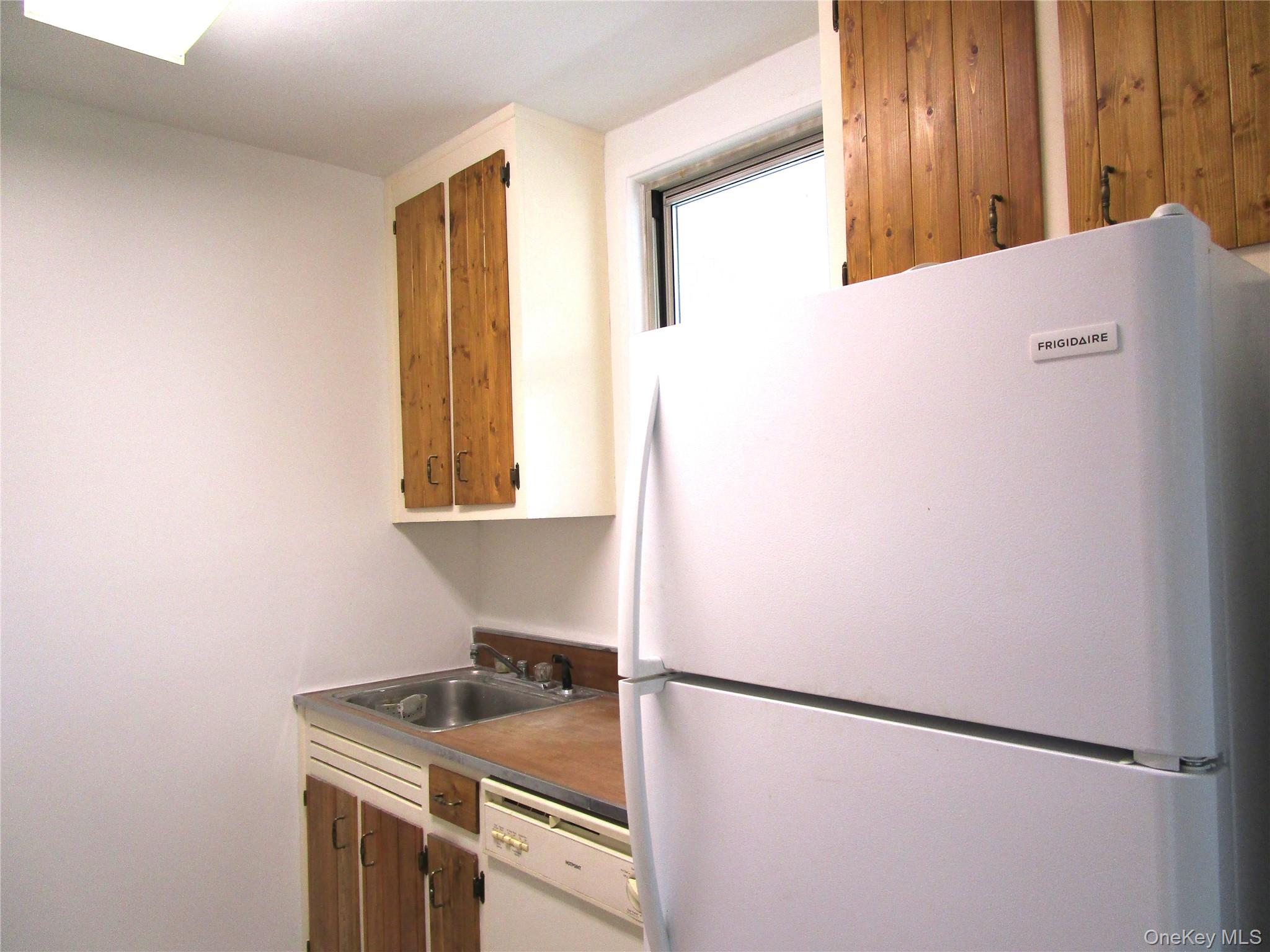 75 Noble Street, Unit 126 Lynbrook, NY 11563 - Photo 15 of 36 a kitchen with a refrigerator and window