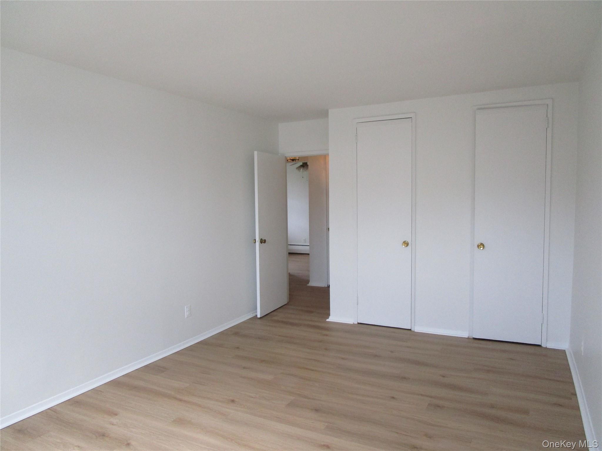 75 Noble Street, Unit 126 Lynbrook, NY 11563 - Photo 24 of 36 a view of an empty room and wooden floor