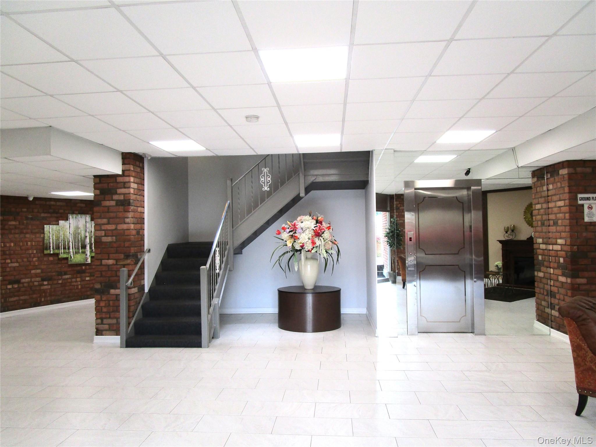 75 Noble Street, Unit 126 Lynbrook, NY 11563 - Photo 6 of 36 a kitchen with a refrigerator and microwave