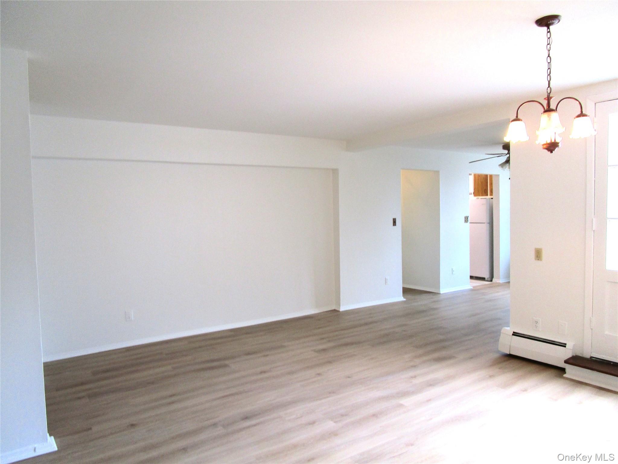 75 Noble Street, Unit 126 Lynbrook, NY 11563 - Photo 10 of 36 a view of a room with wooden floor and white walls