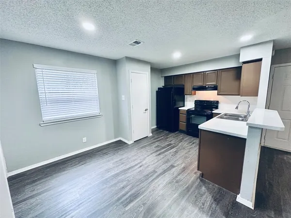 a view of kitchen with wooden floor electronic appliances and window