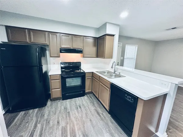 a kitchen with stainless steel appliances a sink a stove a refrigerator and cabinets