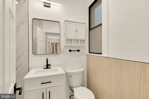 a bathroom with a sink a toilet and mirror