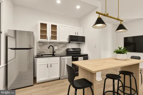 a kitchen with stainless steel appliances granite countertop a refrigerator a stove a sink and a microwave