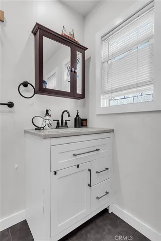 a bathroom with a sink vanity and mirror