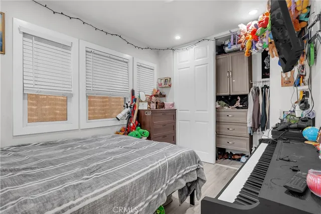 a bedroom with a bed closet and flat tv screen