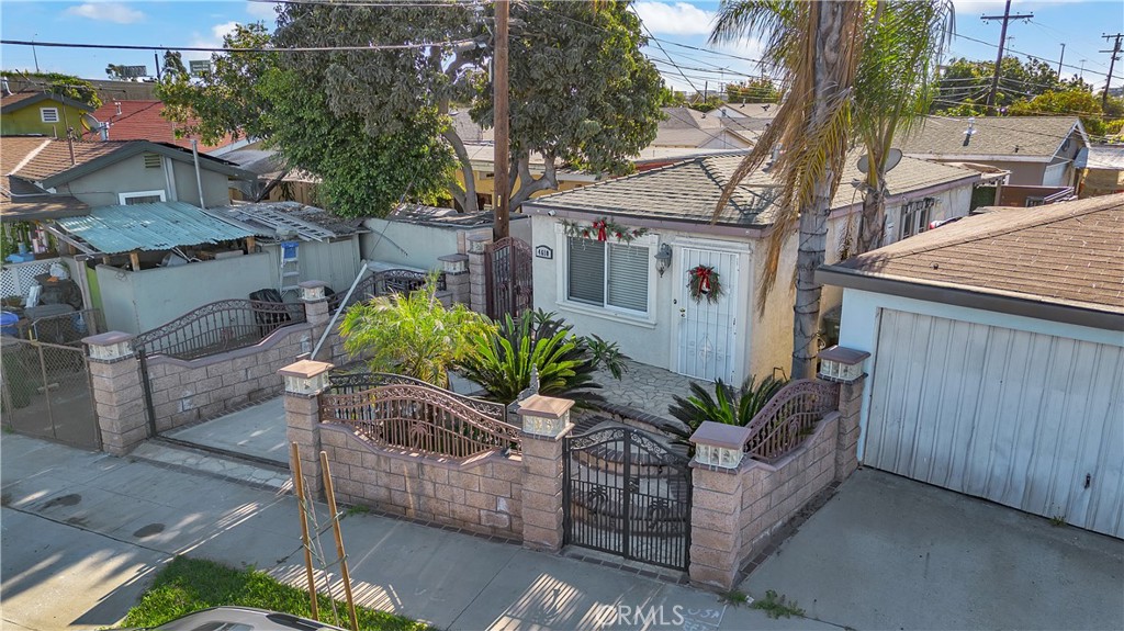 4610 Leonis Street Commerce, CA 90040 - Photo 2 of 32 a view of a white house with a large tree and wooden fence