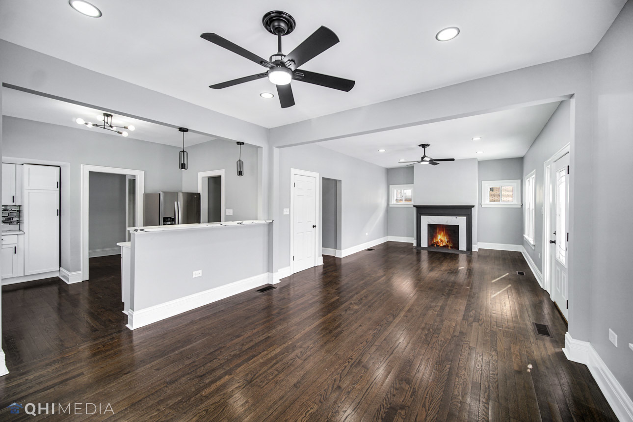 14601 Des Plaines Street Harvey, IL 60426 - Photo 5 of 21 a view of a livingroom with a ceiling fan wooden floor and a kitchen