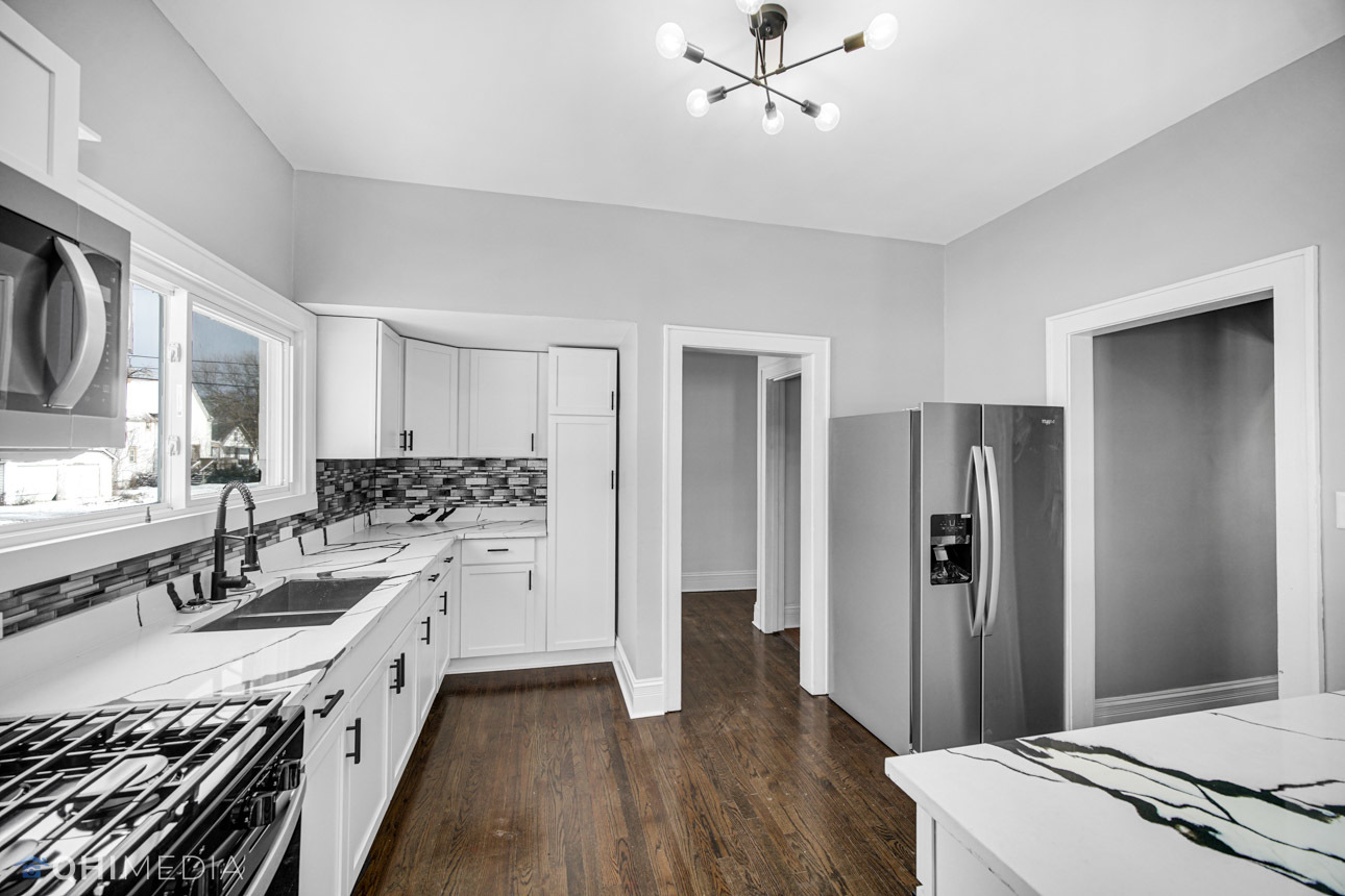 14601 Des Plaines Street Harvey, IL 60426 - Photo 7 of 21 a large white kitchen with a refrigerator a sink dishwasher a stove and white cabinets with wooden floor