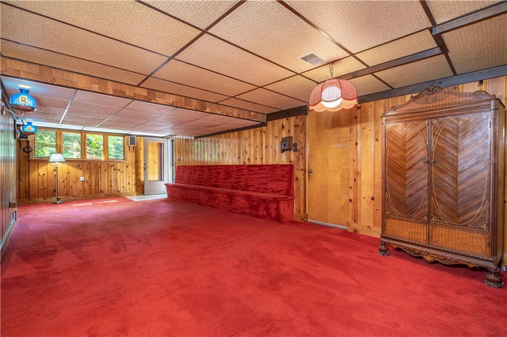 115 Center Church Road Canonsburg, PA 15317 - Photo 18 of 25 Lower level game-room: First door leads to integral garage, open door at end leads to driveway. Knotty-pine lap sided walls make for a perfect glow and feel for this special room.