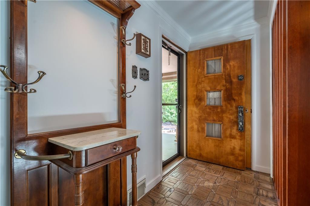 Entry: Inviting and bright, features parquet floor, Two coat closets, and crown molding.