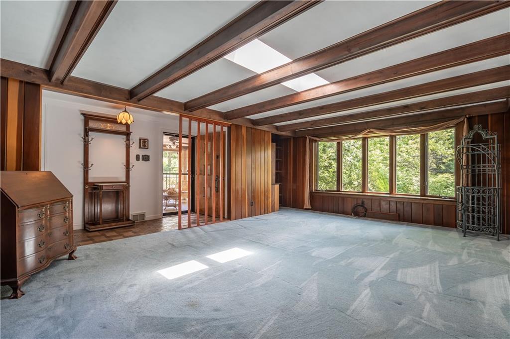 Living room: The blend of features creating a natural setting include Corner built in bookshelves, Vertical cherry wood groove wooden walls, Skylights, Bay window and wooden window seat.