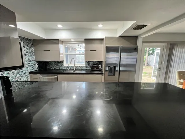 a kitchen with granite countertop a stove and a refrigerator