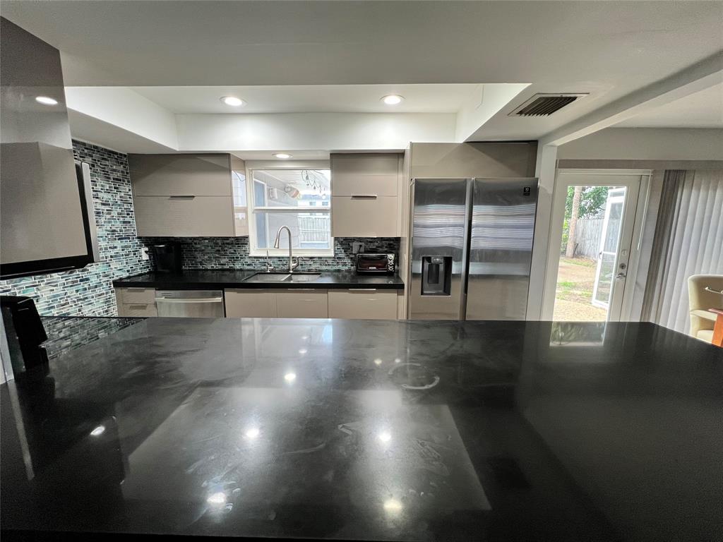 1410 Northeast 56th Court, Unit 1410 Fort Lauderdale, FL 33334 - Photo 2 of 14 a kitchen with granite countertop a stove and a refrigerator