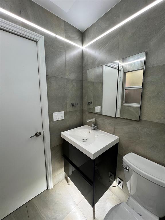 1410 Northeast 56th Court, Unit 1410 Fort Lauderdale, FL 33334 - Photo 8 of 14 a bathroom with a sink toilet and mirror