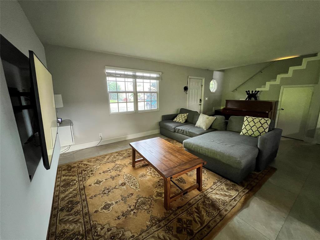 1410 Northeast 56th Court, Unit 1410 Fort Lauderdale, FL 33334 - Photo 10 of 14 a living room with furniture and a flat screen tv