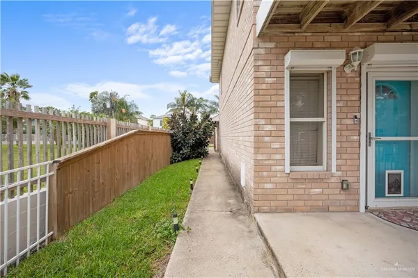 a view of a pathway of a house with wooden fence
