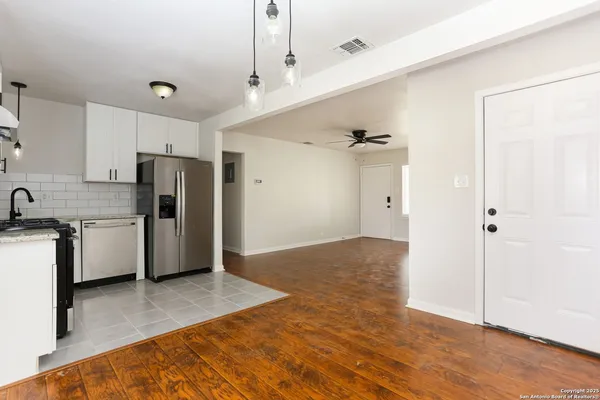 a view of kitchen with refrigerator cabinets and wooden floor